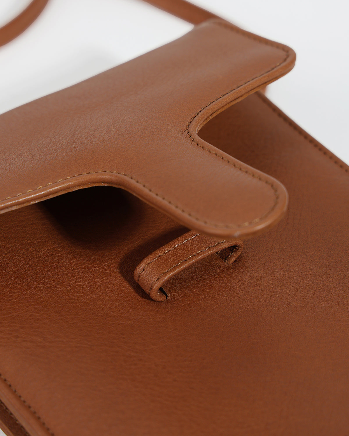 Close-up of a brown leather bag with a handle on a white background