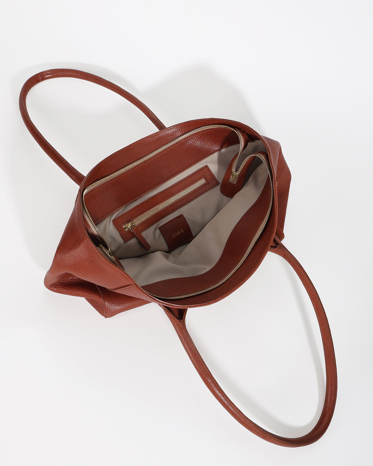 Brown leather handbag with a strap on a white background