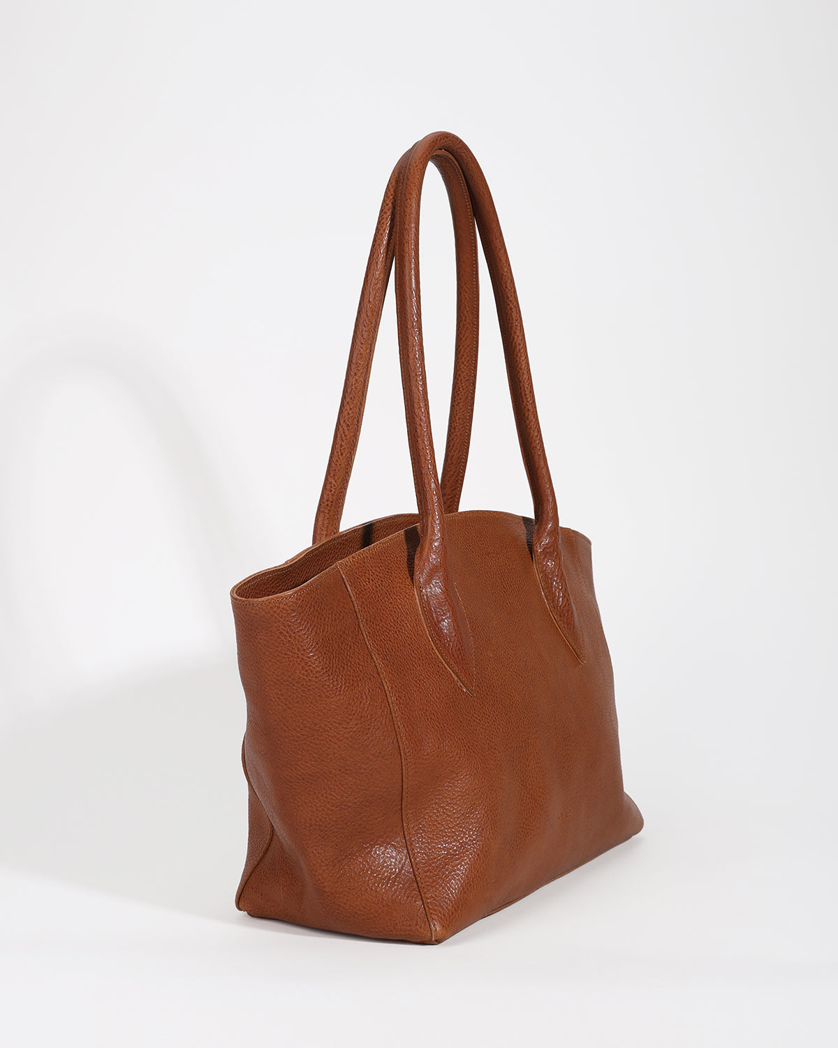 Brown leather tote bag on a white background