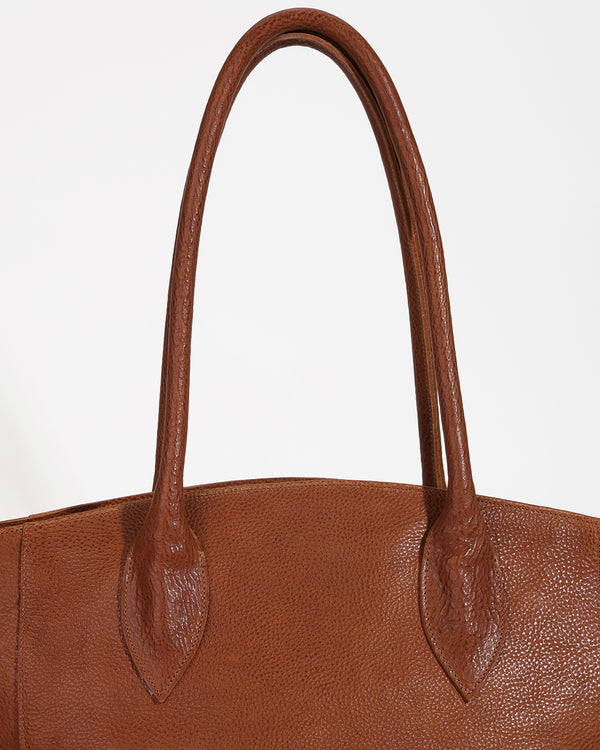 Close-up of a brown leather handbag with a plain background